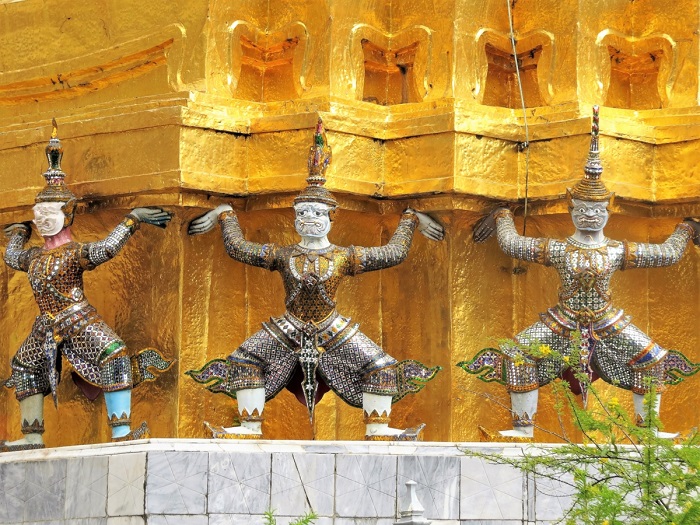Pequenos guardiões sustentam a estrutura no Grand Palace, em Bangkok, Tailândia