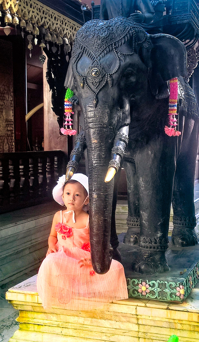 Escultura de elefante e criança junto, no templo Wat Phrathat Doi Sutherp, em Chiang Mai, Tailândia