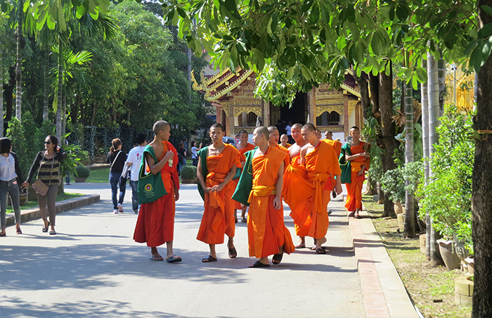 Monges circulam pelo Wat Phra Singh, em Chiang Mai, Tailândia