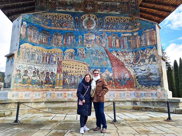 Sônia e João, com a pintura Juízo Final, no Mosteiro de Voront, em Bucovina, Romênia