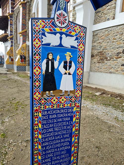 Lápide do Cemitério Alegre ilustrada com um casal em trajes típicos - Sapanta, Romênia.