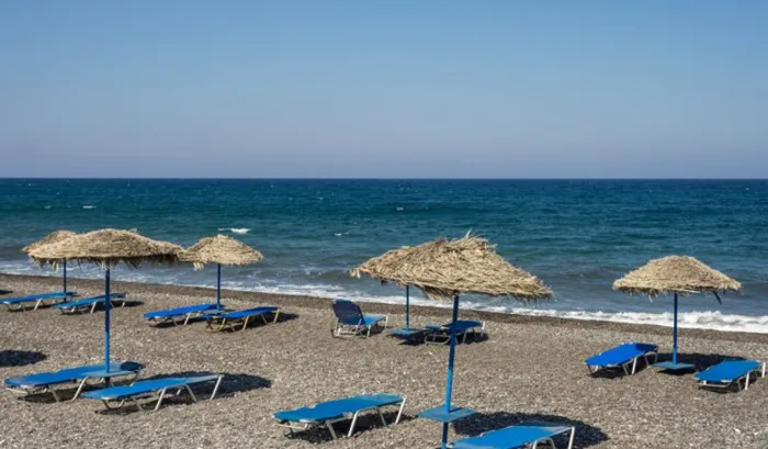 Praia de areia vulcânica, Santorini, Grécia Praia de areia vulcânica, em Santorini, Grécia