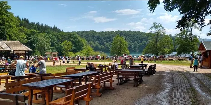 Mesas e bancos para os visitantes no parque dos Lagos Plitvice, na Croácia restaurante