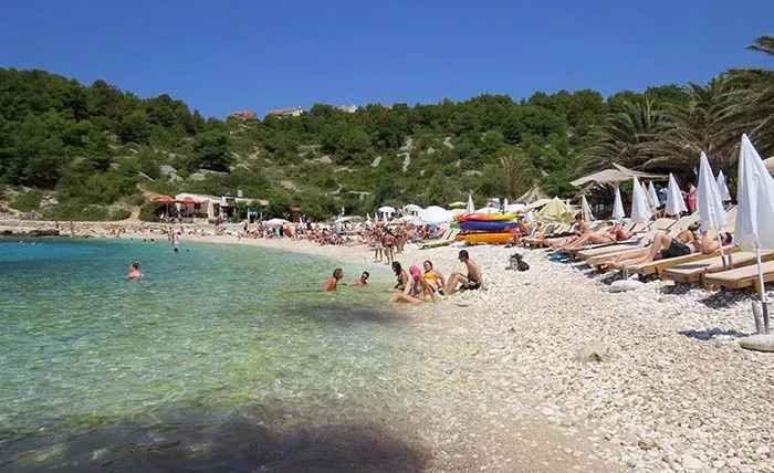 Praia de águas transparentes, em Hvr, Croácia Pláz Pokonji dol, Hvar, Croácia