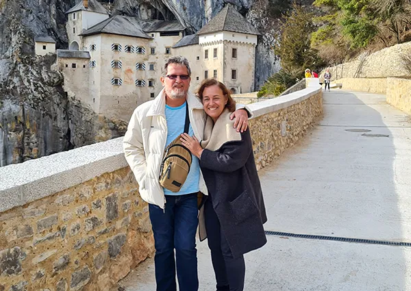 João Miguel e Sônia, no Castelo Predjama, na Eslovênia joao e sonia posam para foto na frente do Castelo Predjama