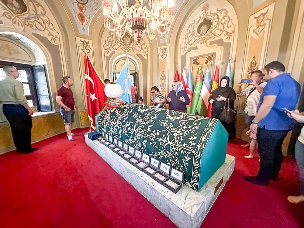 A tumba de Ertugrul, as bandeiras e as caixinhas com a terra dos territórios otomanos em torno - em Sogut, Turquia A tumba de Ertugrul, as bandeiras e as caixinhas com a terra dos territórios otomanos em torno