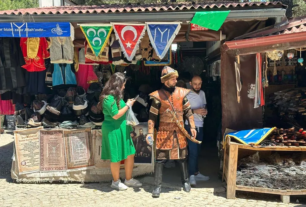 uma lojinha do mausoleu de Ertugrul, em Sogut, Turquia, com um vendedor na porta, vestido com a roupa de um alp uma lojinha do mausoleu de Ertugrul, em Sogut, Turquia